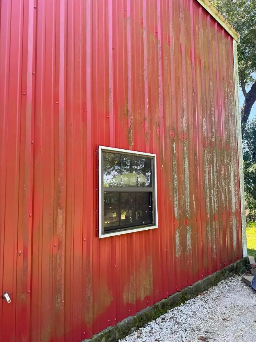 Red metal barn wall — algae & mildew lifted — before