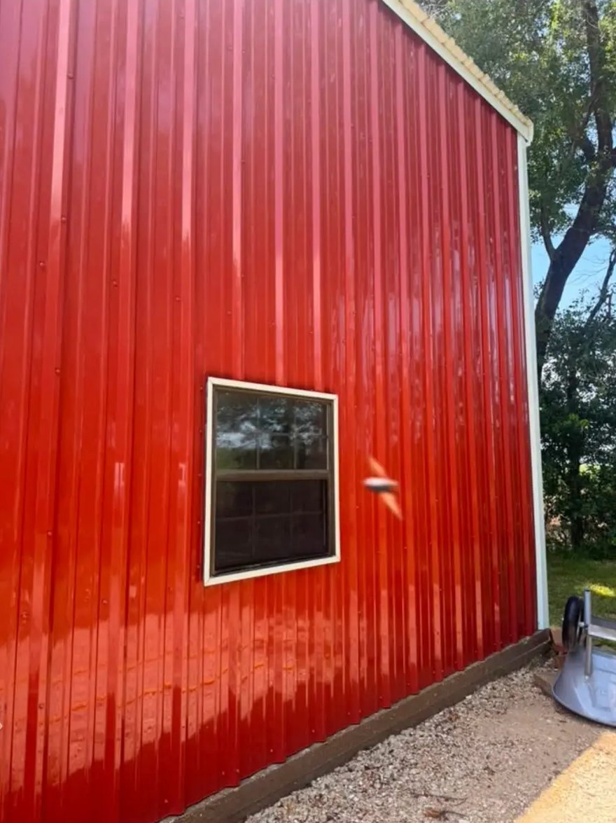 Red metal barn wall — algae & mildew lifted — after